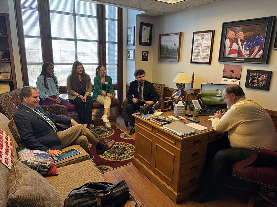 西北总裁博士. 兰斯·塔图姆(右)和学生们一起会见了州议员.